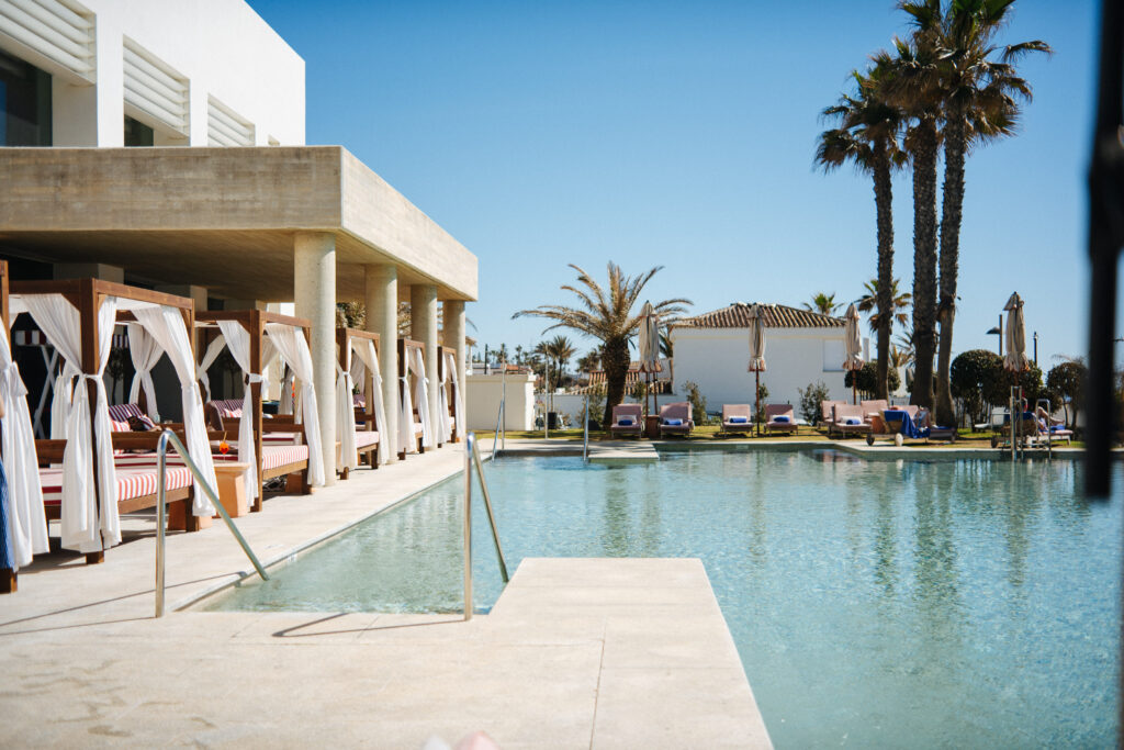 pool and cabanas in a beach club by a hotel