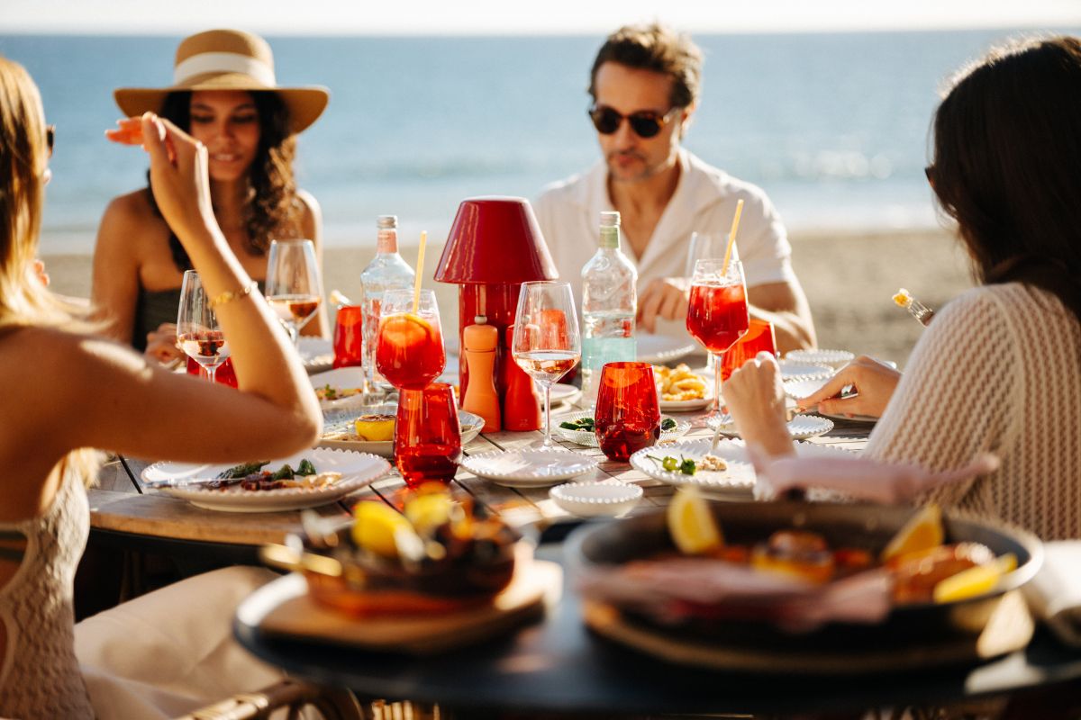 group dining at an outdoor restaurant by the beach