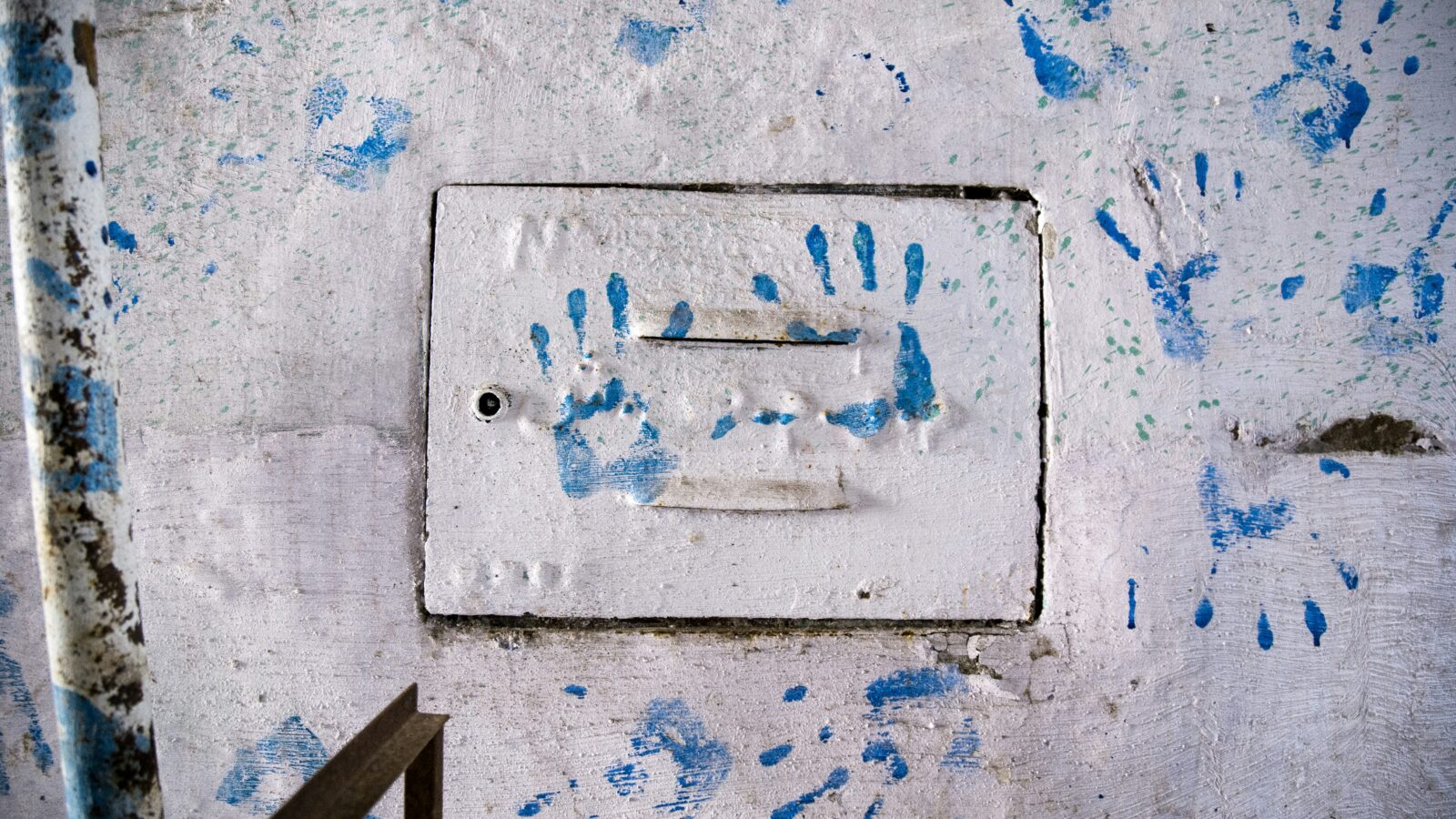 Blue hand prints on wall
