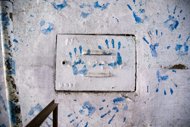 Blue hand prints on wall