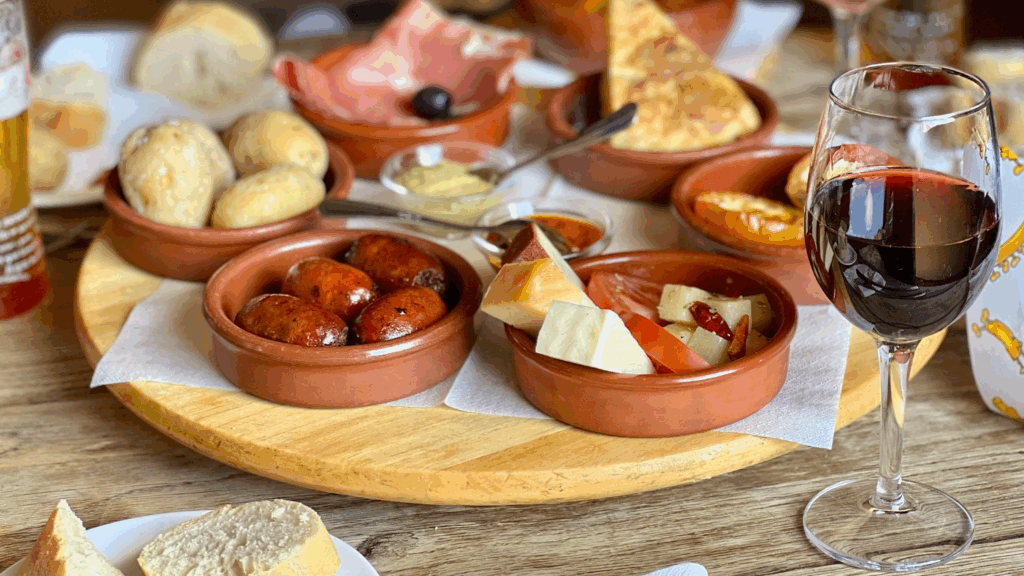 An assortment of tapas dishes with red wine glass